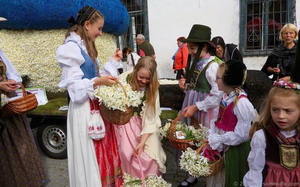 children in traditional clothes with baskets of narcissus poeticus